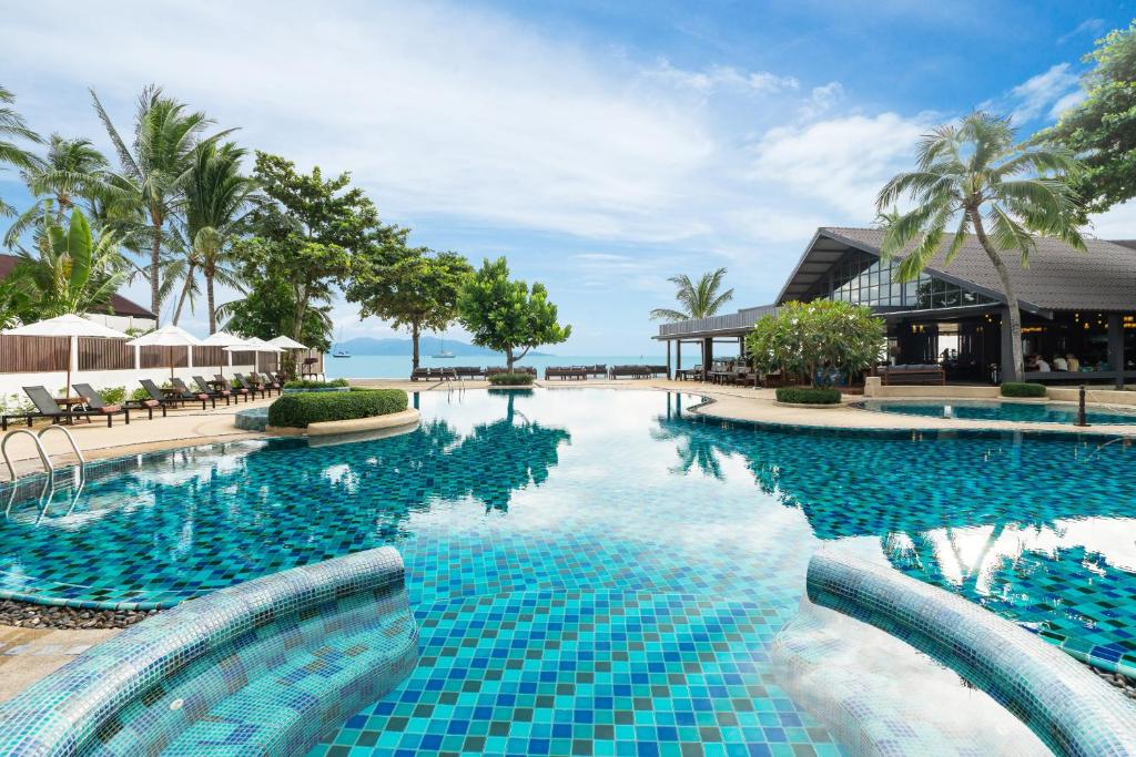 - une piscine dans un complexe avec du carrelage bleu dans l'établissement Peace Resort Samui, à Bophut 