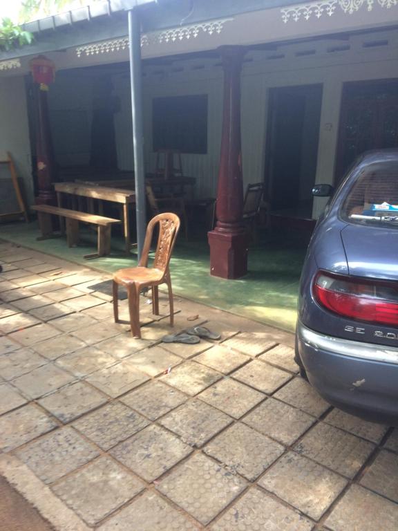 a chair sitting on a patio next to a table at Low budget pilgrim home in Anuradhapura