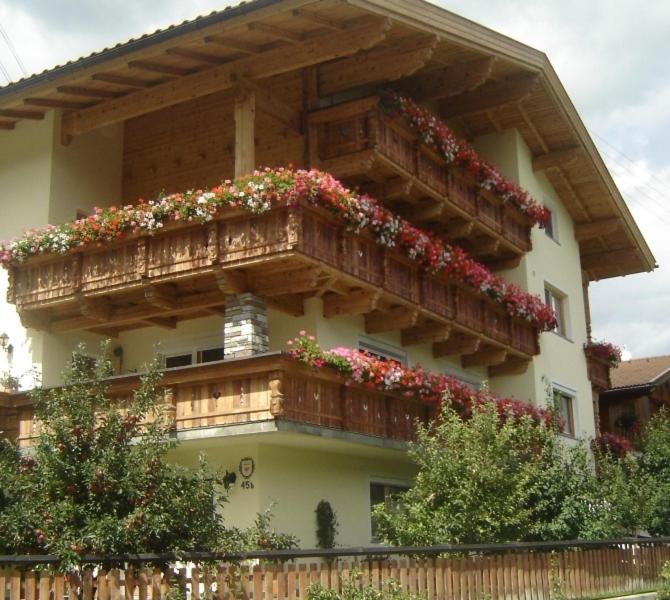 un edificio con un balcón con flores. en Ferienwohnung Kainer Carina, en Ried im Zillertal