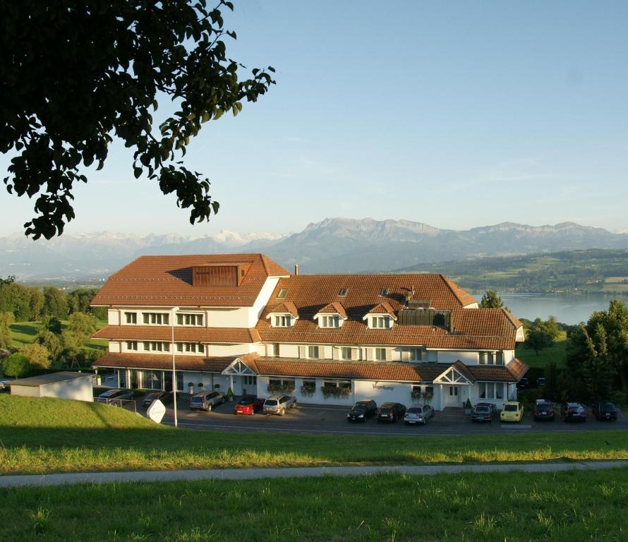 ein großes Gebäude mit Autos auf einem Parkplatz in der Unterkunft Hotel Restaurant Vogelsang in Eich