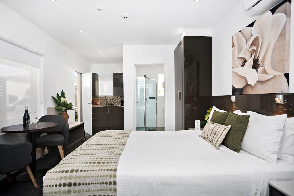 a bedroom with a large white bed and a desk at North Adelaide Boutique Stays Accommodation in Adelaide