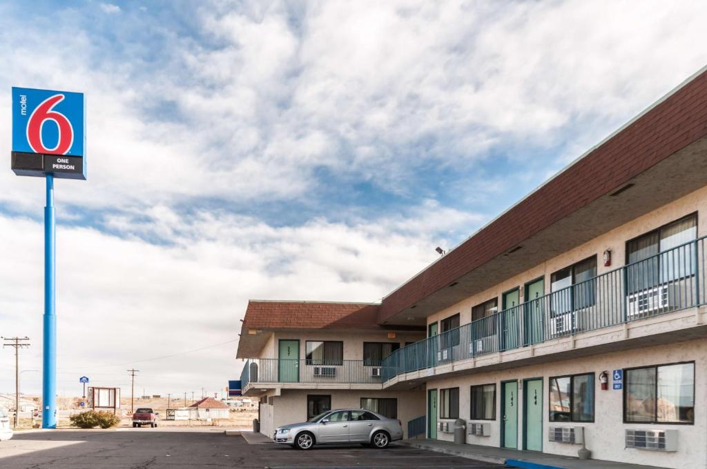 un coche aparcado frente a un edificio en Motel 6-Green River, UT, en Green River