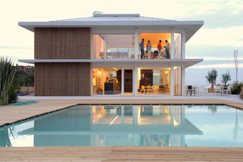 uma casa com uma piscina em frente em Pomposa Residence em Lido di Pomposa