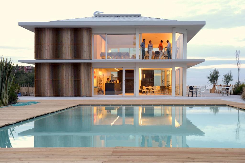 a house with a swimming pool in front of it at Pomposa Residence in Lido di Pomposa