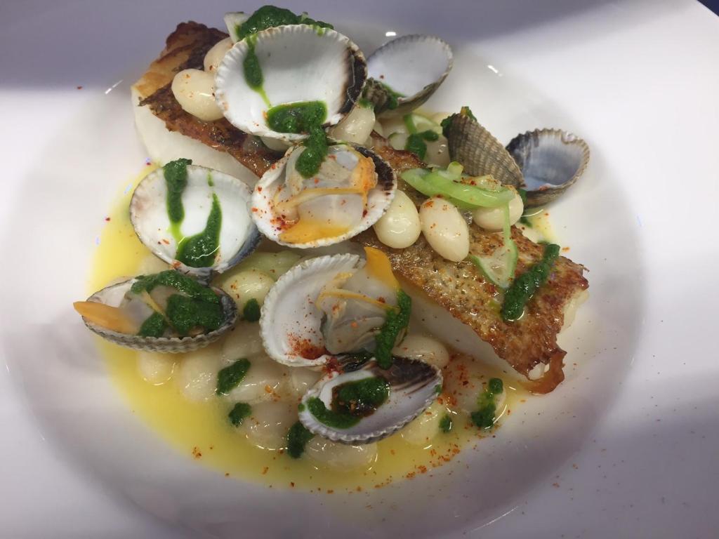 a plate of food with oysters and onions on a plate at Hotel-Restaurant Lann Roz / Côte Cuisine in Carnac
