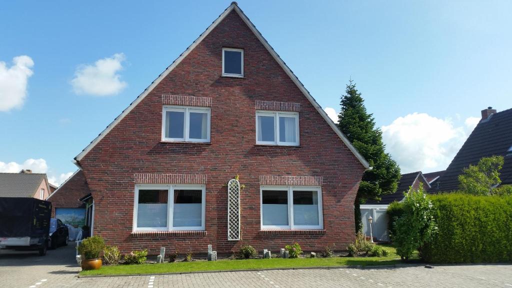 a red brick house with a triangular roof at Dat Inselhuus in Norden