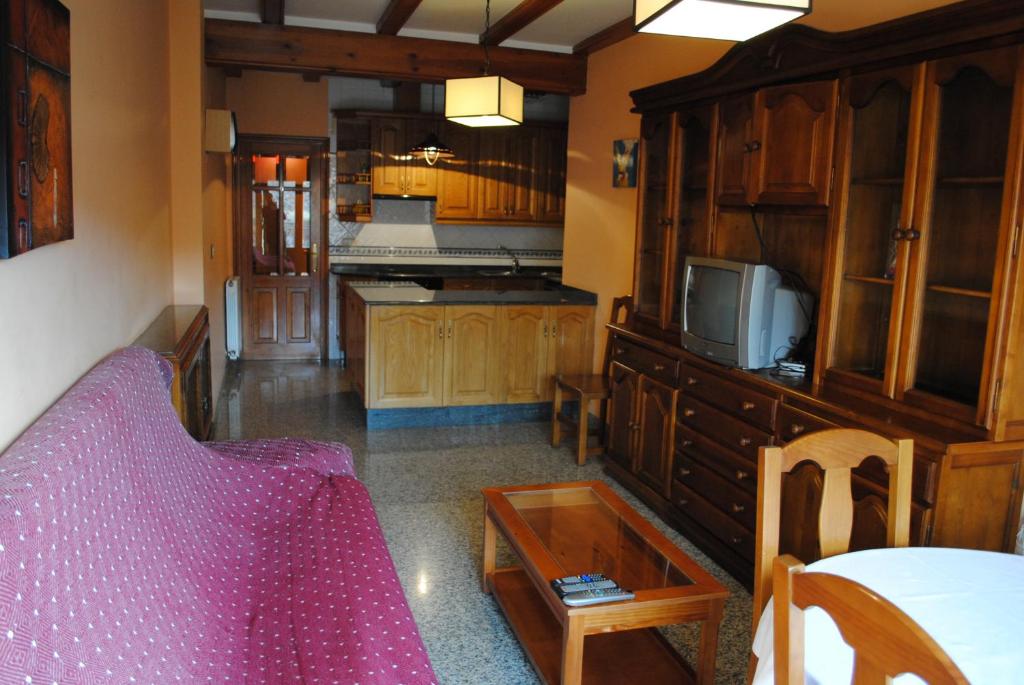 a kitchen with wooden cabinets and a tv on a counter at APARTAMENTOS RIO MORA 2 in Mora de Rubielos
