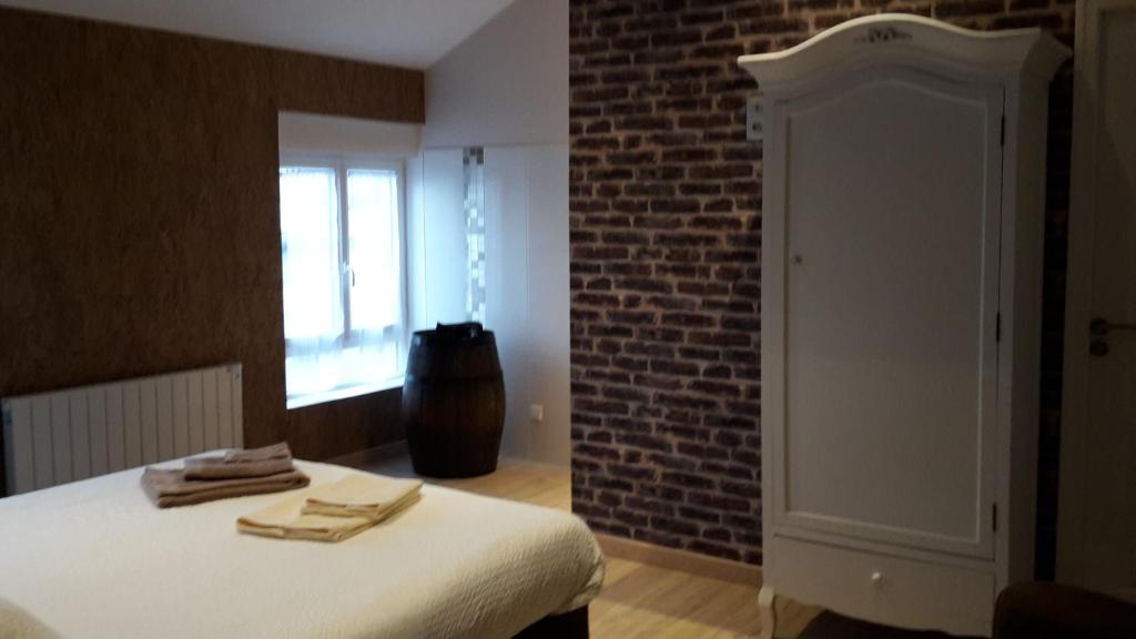 a bedroom with a bed and a brick wall at Chambre d'Hotes de la Loge in Moussy