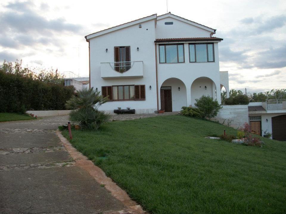 een groot wit huis met een grasveld bij Le Grotte di Notar in Castellana Grotte