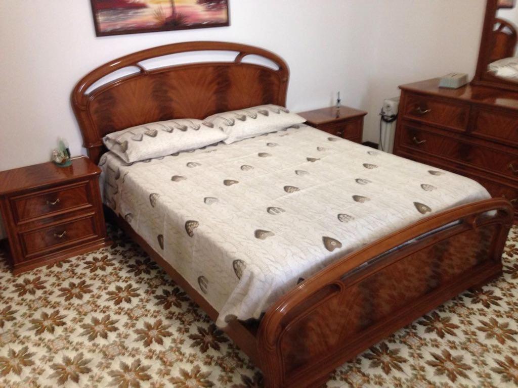 リーパリにあるCasa vacanza Lipariのベッドルーム1室(木製ベッド1台、ドレッサー2台付)