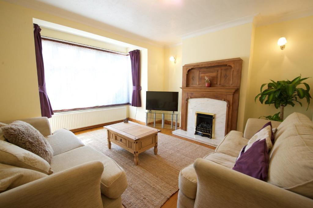 a living room with a couch and a fireplace at Barnet 3 Bedroom House in London
