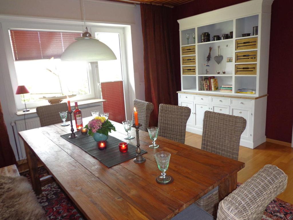 een eetkamer met een houten tafel en stoelen bij Ferienwohnung _ Ferienhaus Krebs in Kiel