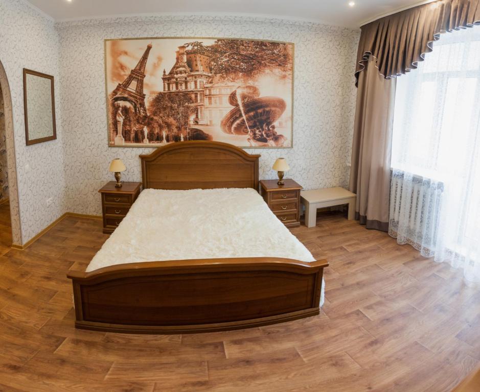 a bedroom with a bed and a painting on the wall at Apartment on Lenina 69А in Tyumen