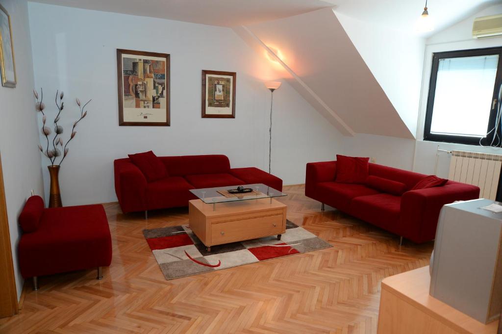 a living room with two red couches and a coffee table at Superior Skopje Apartments in Skopje