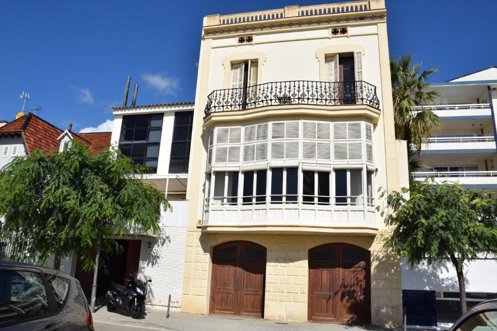 biały budynek z balkonem w obiekcie Apartamentos Les Barbes w mieście Caldes d'Estrac
