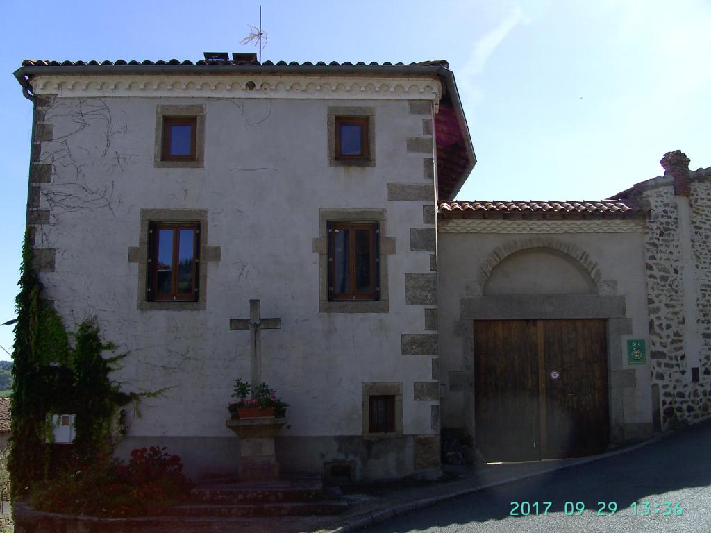 un edificio con una cruz a su lado en La Fontaine, en Saint-Georges-en-Couzan