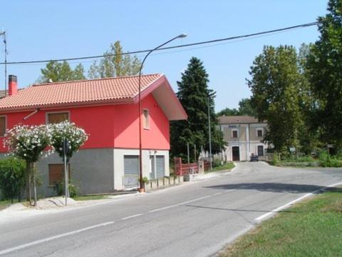 een rood huis aan de kant van een straat bij B&B da Zio Gianni in Fratta Polesine