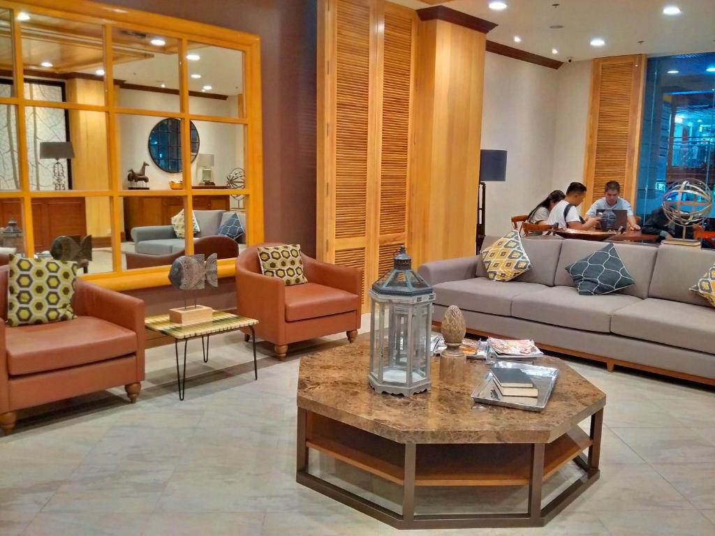 sala de estar con sofás, sillas y mesa en Cedar Peak Condo - Close to Session Road City Center en Baguio