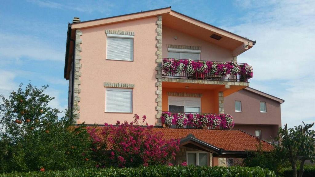 a pink building with flowers on the balconies at Rooms Mario in Međugorje