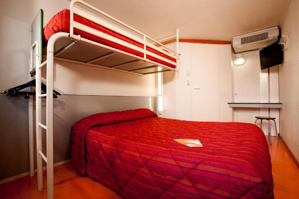 1 dormitorio con litera y colcha roja en Premiere Classe Mulhouse Sud Morschwiller, en Morschwiller-le-Bas