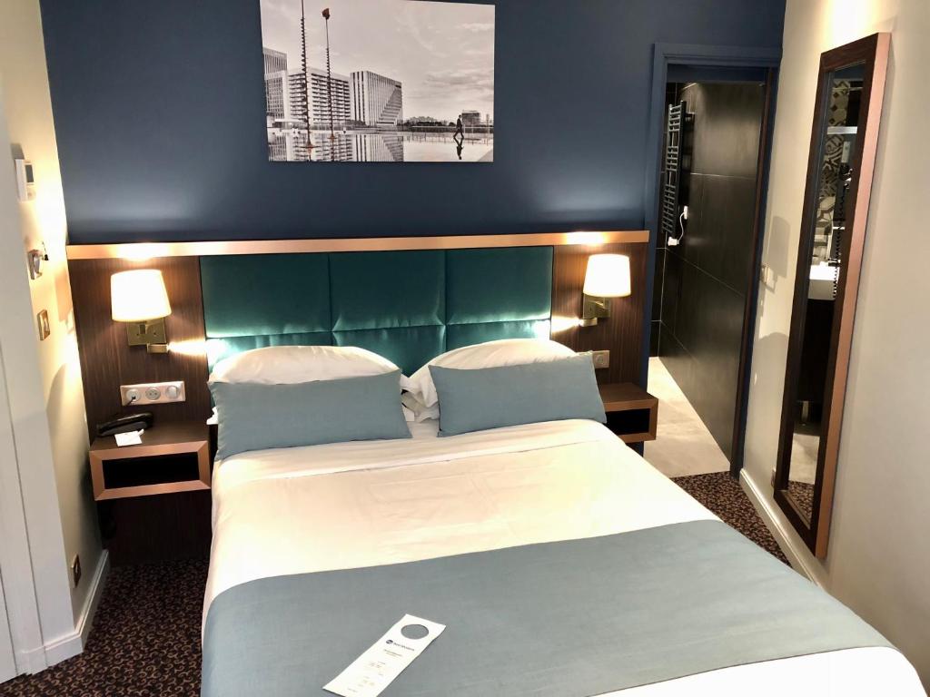 a bedroom with a large bed with a green headboard at Best Western Empire Elysees in Paris