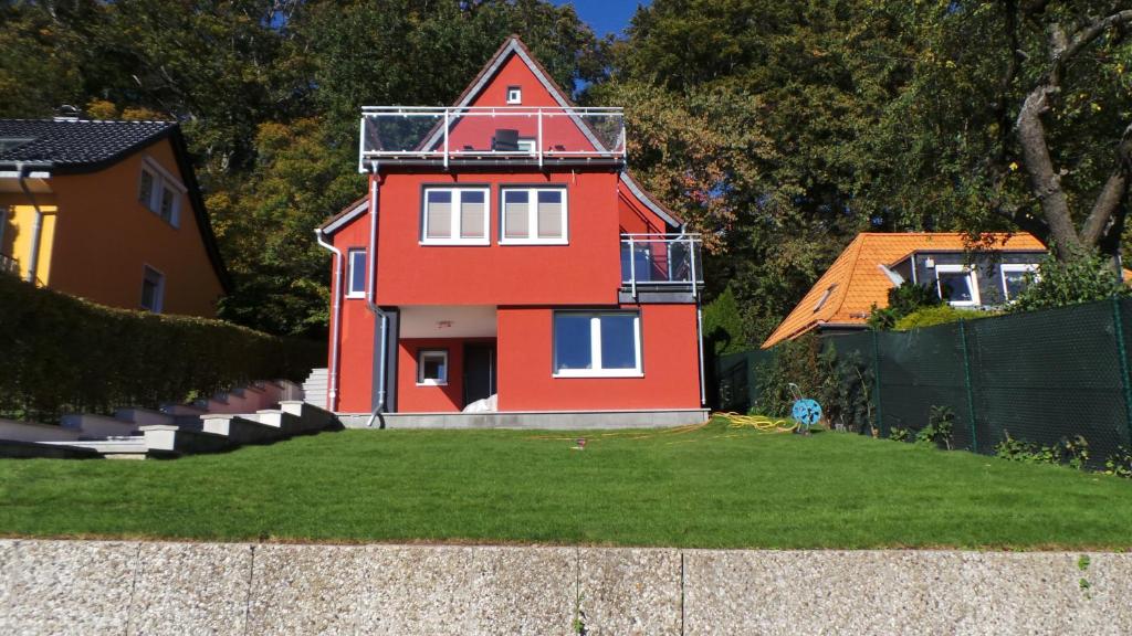ein rotes Haus mit einem Balkon auf einem Hof in der Unterkunft Villa Moma in Bad Harzburg