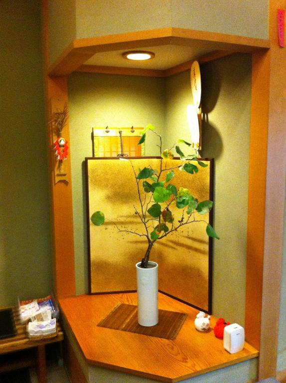 a plant in a white vase sitting on a table at Kyonoyado Kagihei in Kyoto
