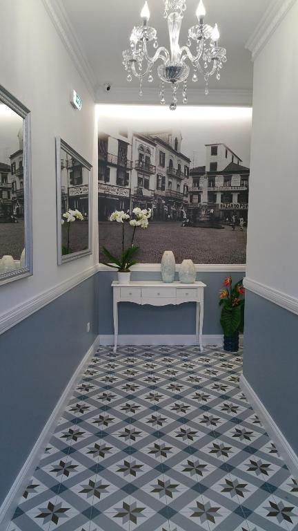 a hallway with a white bench and a chandelier at Edificio Charles 104 in Funchal