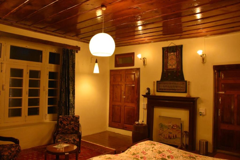 a bedroom with a bed and a fireplace at Deodar Manor - Guest House Khajjiar in Khajjiar 