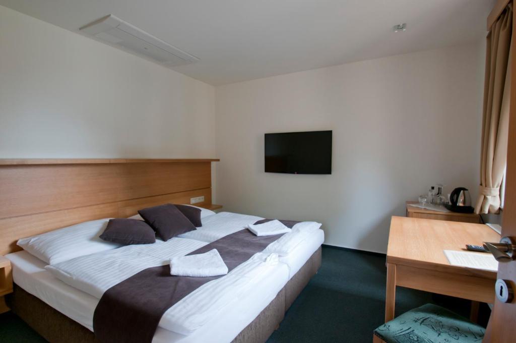 Postel nebo postele na pokoji v ubytování Hotel resort Lovecká bašta Strakonice