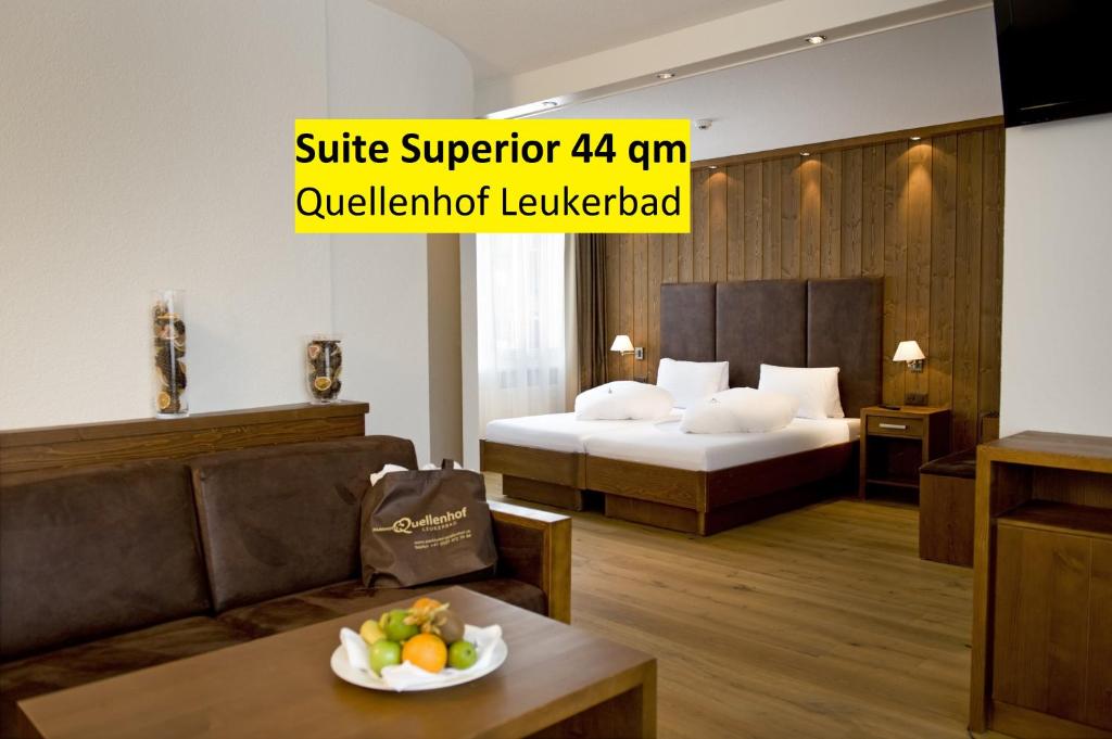 a hotel room with a bed and a table with a bowl of fruit at Hotel Quellenhof Leukerbad in Leukerbad