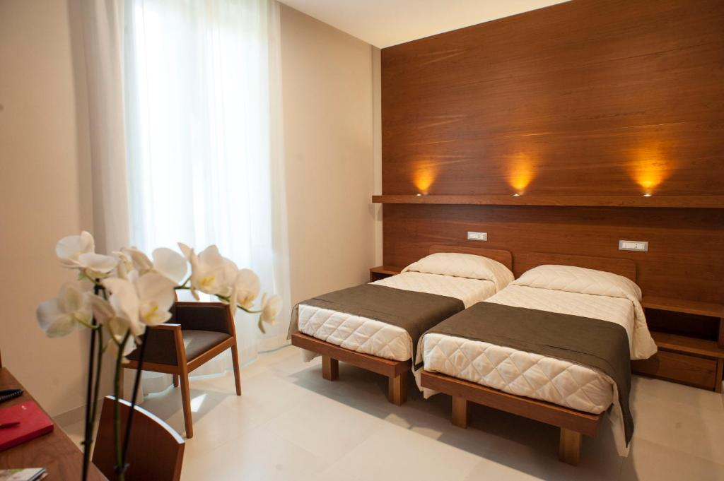 a bedroom with two beds and a wooden headboard at Villa Angelina in Rome