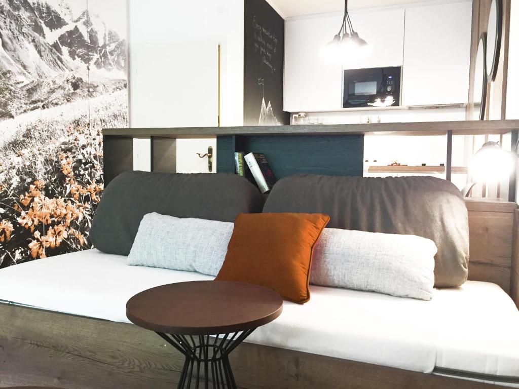 un sofá con almohadas y una mesa en una habitación en Sun Valley Apartment, en Bad Hofgastein