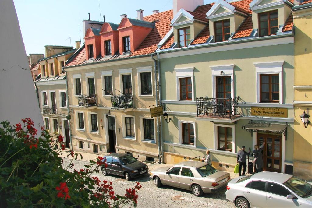 a group of buildings with cars parked on a street at Apartamenty Furta Dominikańska in Sandomierz