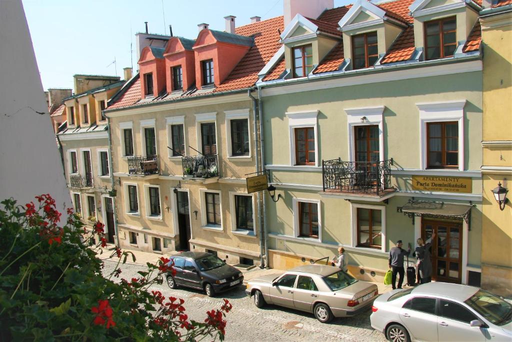 eine Gruppe von Gebäuden mit Autos, die auf einer Straße geparkt sind in der Unterkunft Apartamenty Furta Dominikańska in Sandomierz