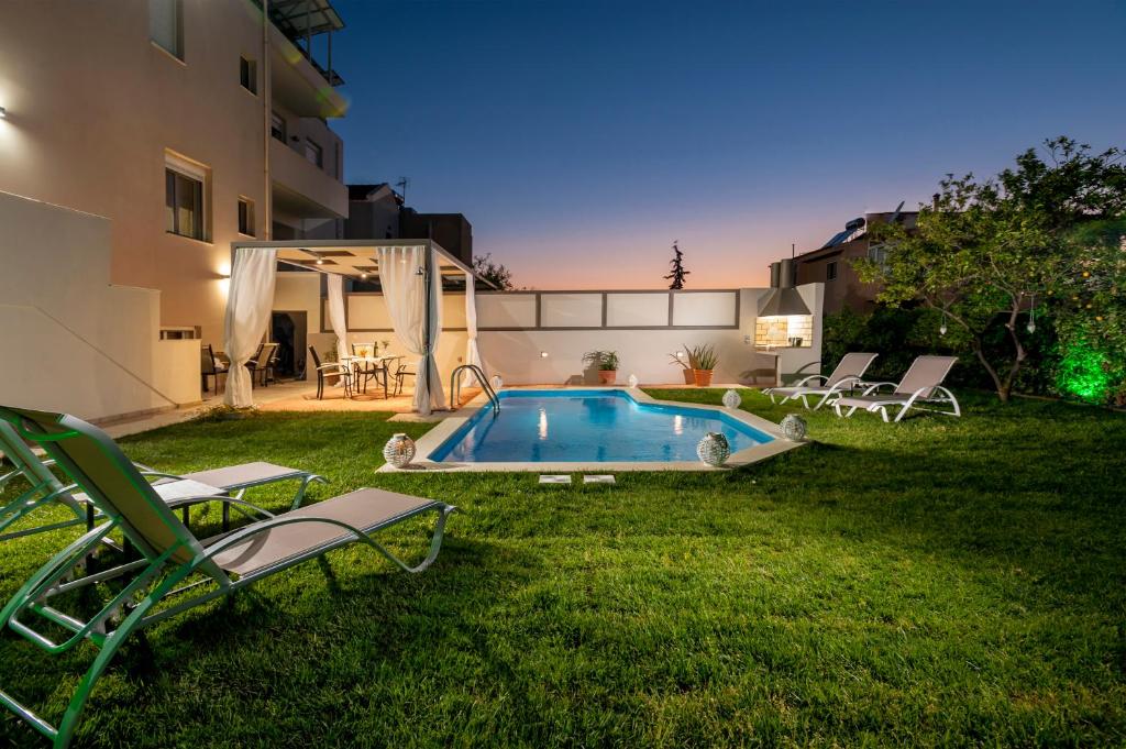 a backyard with a swimming pool and lawn chairs at Dream Villa in Kambánion