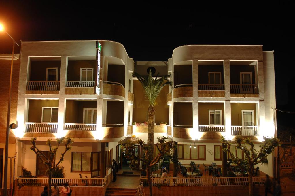 duży biały budynek z palmą przed nim w obiekcie Hostal La Palmera w mieście Miajadas