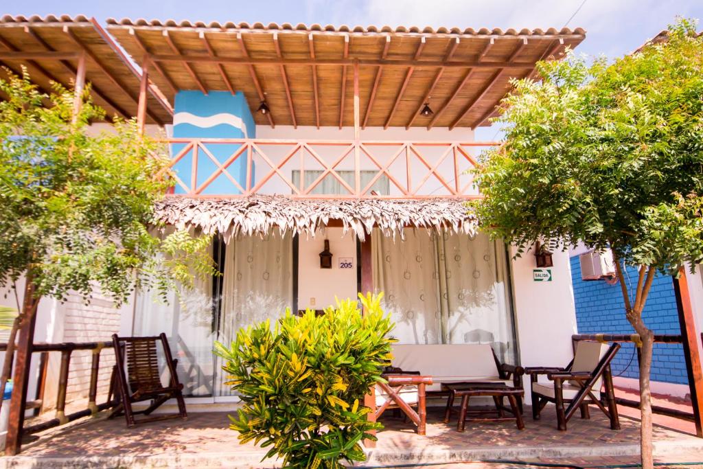 a patio with chairs and a pergola at Nauti-k Beach Hotel in Tumbes