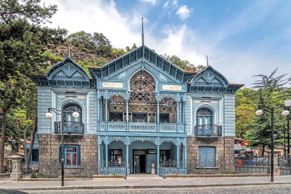 un bâtiment bleu sur le côté d'une rue dans l'établissement Golden Tulip Borjomi, à Bordjomi