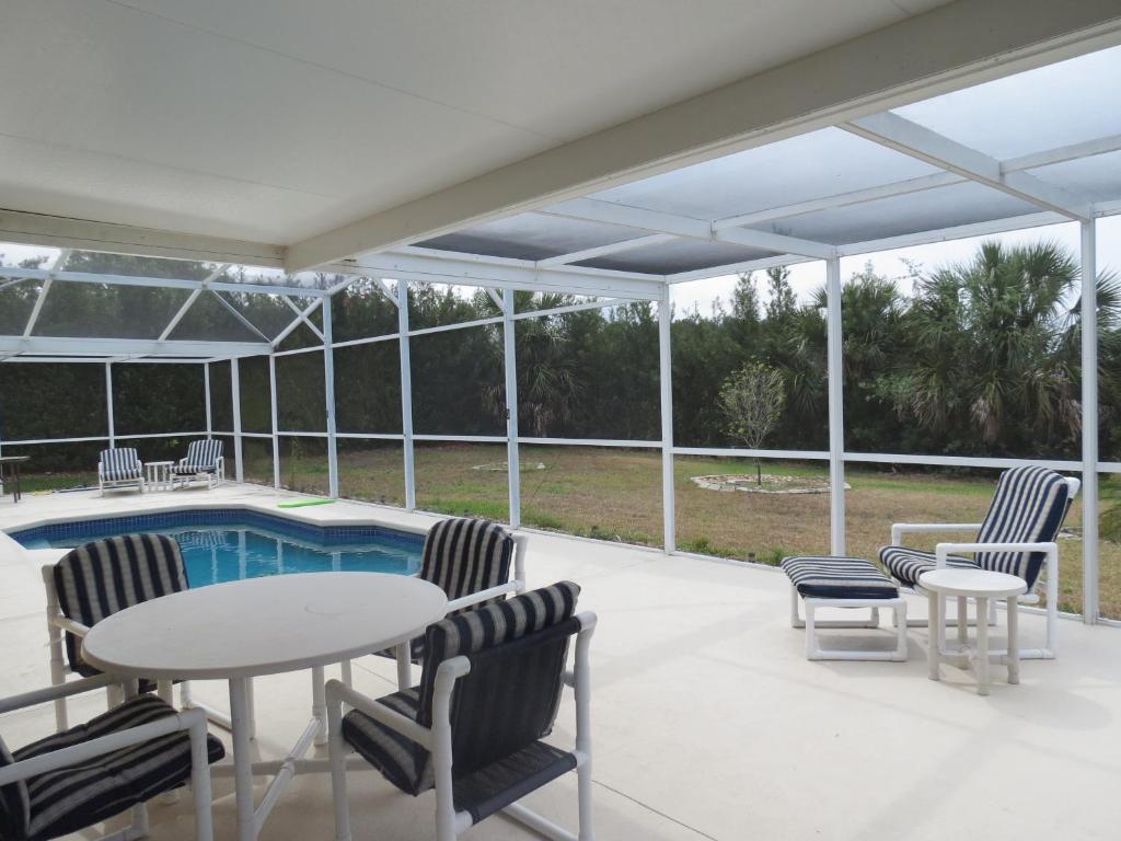 a patio with chairs and a table and a pool at Westridge Pool Home in Davenport
