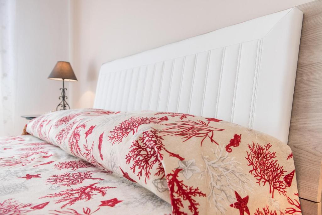 Una cama con almohadas rojas y blancas. en La Castellese, en Aci Castello