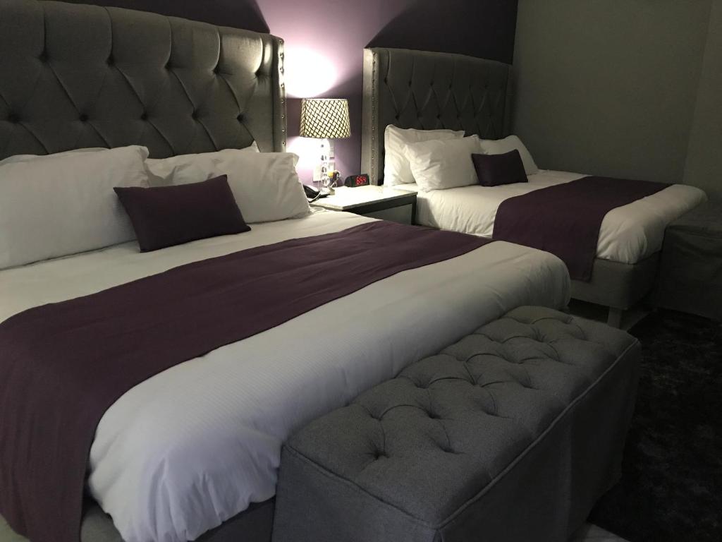 Habitación de hotel con 2 camas y sofá en Gran Hotel Cantera La plaza, en Nuevo Laredo