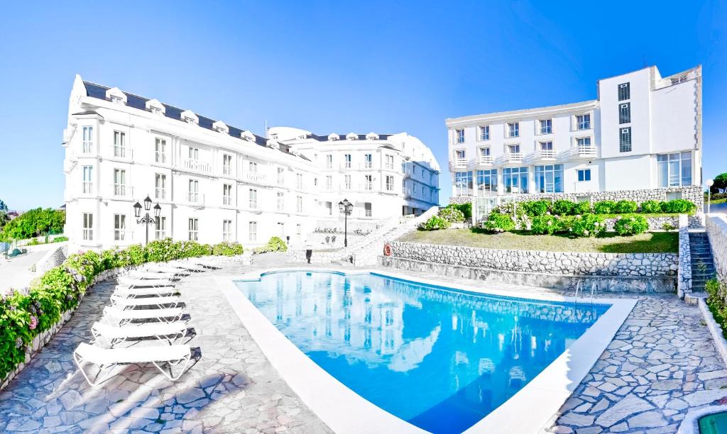 un hotel con piscina frente a un edificio en Gran Hotel Suances, en Suances