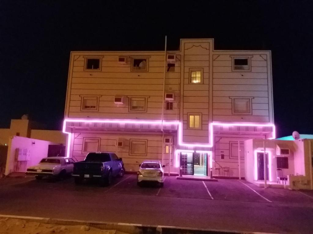 ein Gebäude mit lila Lichtern an der Seite in der Unterkunft المسرة سكن للعزاب فقط in Yanbu