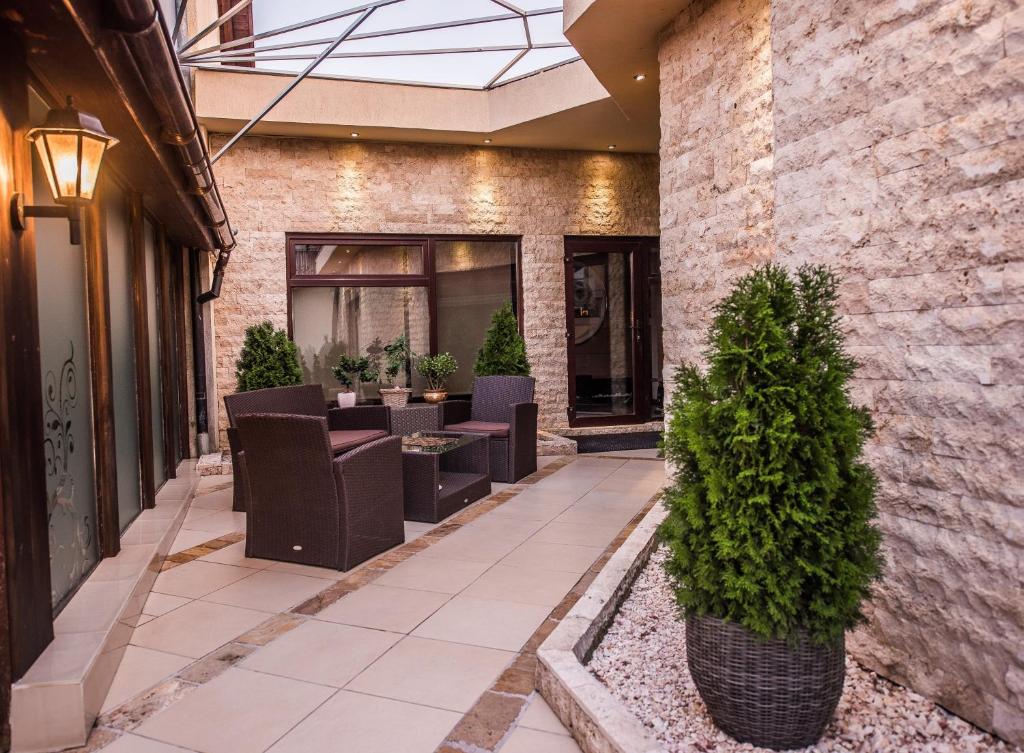 un patio con sedie e alberi di fronte a un edificio di H & V Residence - Split Level Apartment a Arad