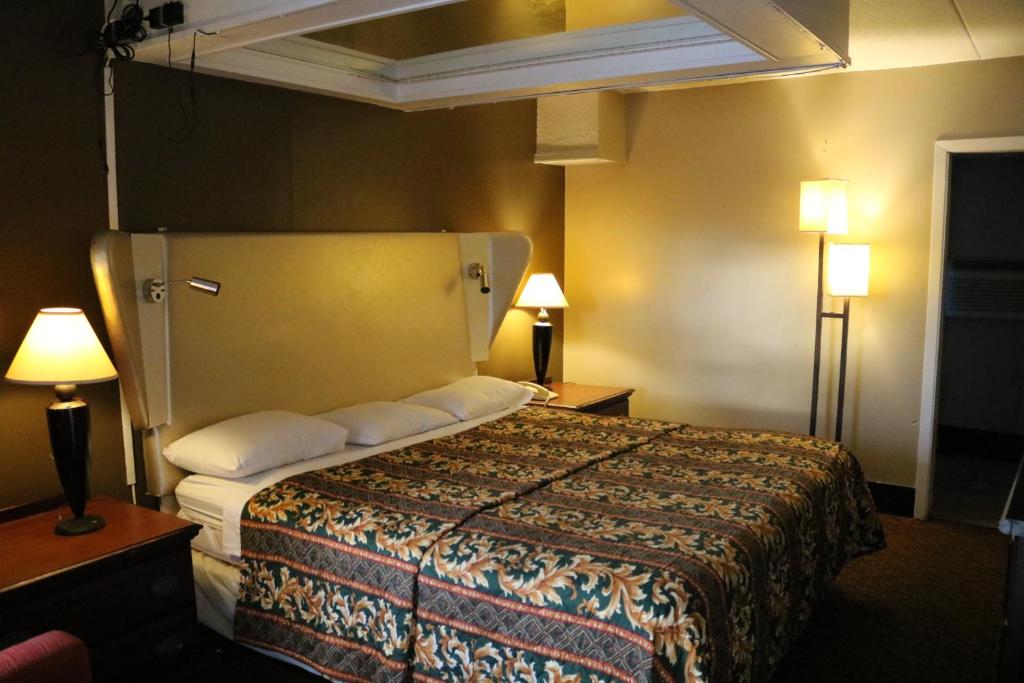 a hotel room with a bed and two lamps at Miami Inn & Suites in Chicago