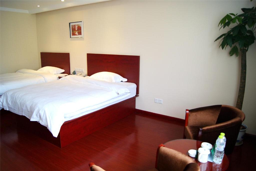 a bedroom with two beds and a table and a chair at GreenTree Inn Hebei Langfang Sanhe District Fudi square Express Hotel in Gaolou