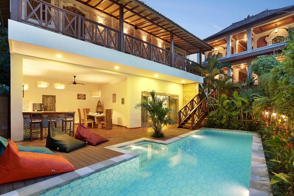 a house with a swimming pool in front of a house at Danaya's villa in Ubud