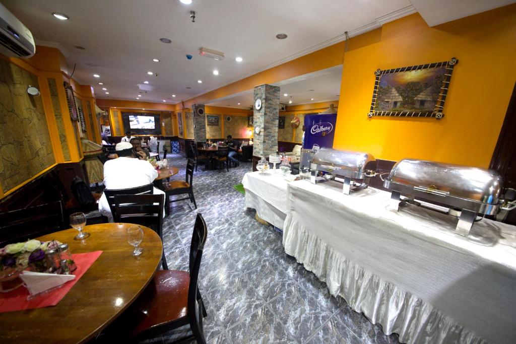 a restaurant with two long tables and chairs at White Fort Hotel in Dubai