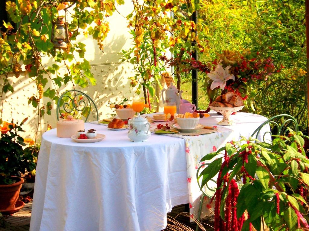 a table with a white table cloth with food on it at Chambres "Au Jardin" in Biscarrosse
